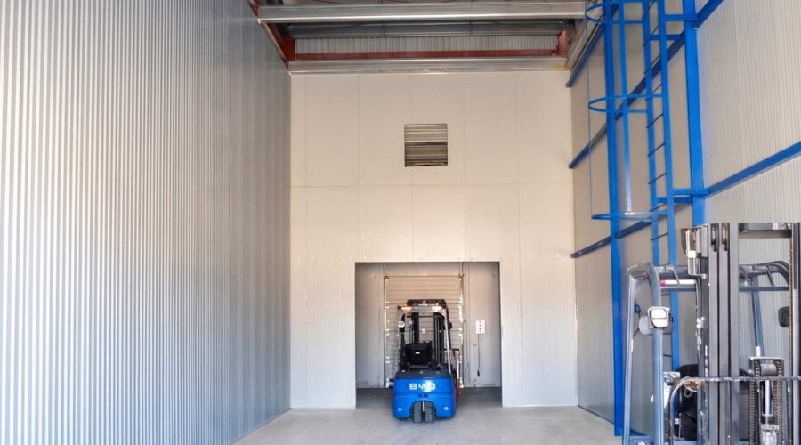 Интерьер морозильной камеры с погрузчиком · Interior of a freezer chamber with a forklift · Тиегіші бар мұздатқыш камераның ішкі көрінісі