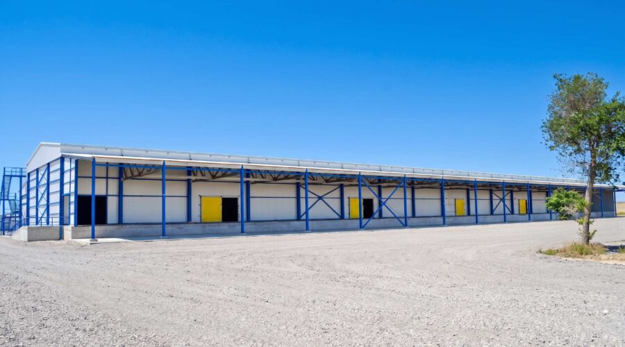 Фасад склада с жёлтыми воротами доков · Warehouse facade with yellow dock doors · Сары док қақпалары бар қойма қасбеті